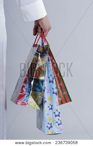 Hand Holding Shopping Bags With Gifts