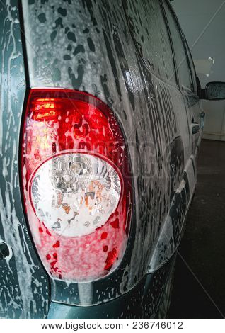 Car Wash. Lather Drips Down And Dissolves The Dirt On The Body And The Back Of The Headlamp Of The C