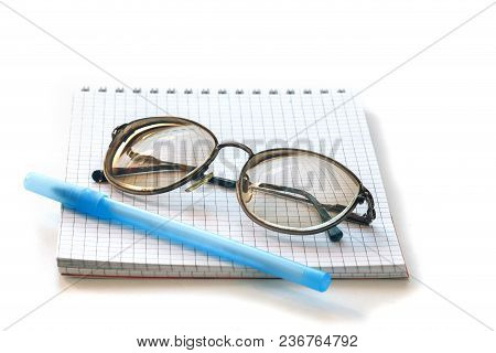 Glasses In Metal Frame, Notepad And Pen On White Background