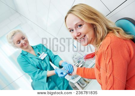 Blood test with disposable lancelet. nurse and woman at clinic