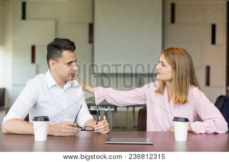 Confident Businesswoman Tapping Male Colleague On Shoulder At Coffee Break. Young Caucasian Business