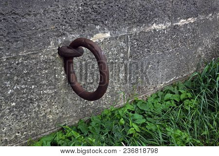 The Large Rusty Metal Ring For Mooring Is Immured In The Wall
