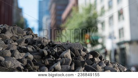 Rubble stones in city with businessman holding laptop