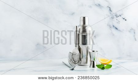 Set Of Bar Accessories For Cocktail Making. Shaker, Jigger, Strainer, Spoon On A Marble Background. 