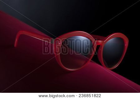 Sunglasses For Women Red Color, On Red Surface With Dark Background