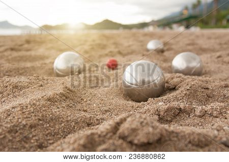 Beach. A Game Of Bocha. Brilliant Silver Balls For A Bocha On The Sand.