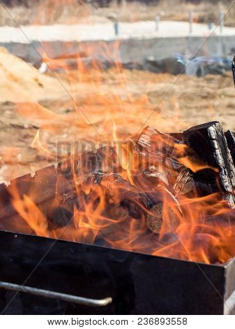 Fire From Burning Wood In The Grill Outdoors