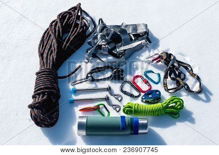 Close-up Of Winter Climbing Equipment On Fresh Snow On A Sunny Day. Carbines With A Rope Gazebo And 