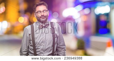 Middle age man, with beard and bow tie making funny face fooling at night club