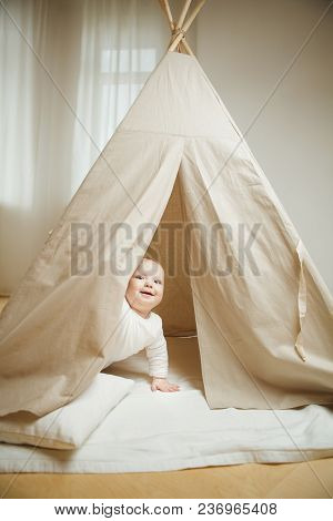 Curious Child Peeps Into The Childrens Tent Full Of Cosy Pillows. Smiling Baby Playing, Toddler Eage