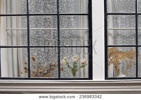 The Traditional Dutch Window With Tulle And Dry Bouquets On The Windowsill