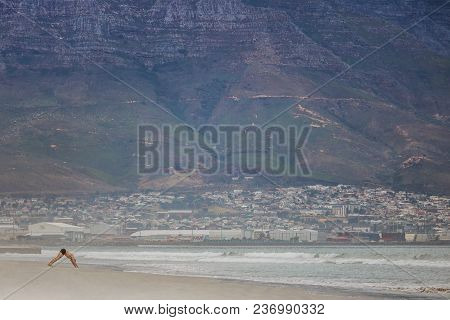 Man Exercising On Paarden Eiland Beach At Sunrise With Table Mountain And Cape Town City In The Back