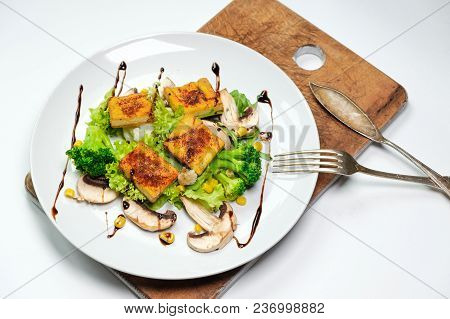 Vegetarian Breakfast Of Broccoli Tofu. On A White Plate On A Wooden Board