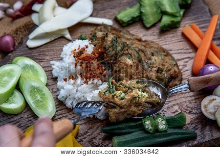 A Local Thai Food Style, The Hand Is Using A Spoon To Scoop Fried Acacia Pennata Omelet Or Cha-om Eg