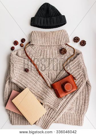A Warm Wool Sweater And An Old Camera In A Leather Case. Hat And Books.