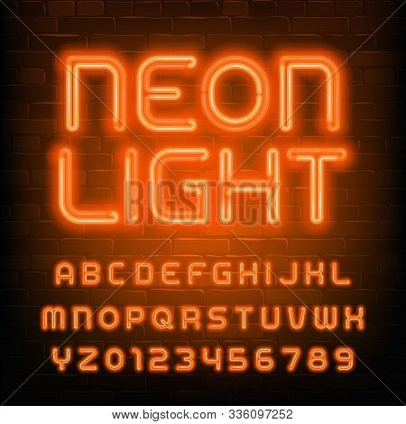 Neon Light Alphabet Font. Simple Orange Neon Letters And Numbers. Brick Wall Background. Stock Vecto