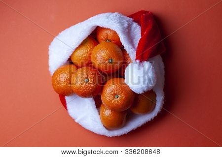 Christmas Tangerines In A Santa Hat On An Orange Background, Christmas Fruits, Festive Symbol