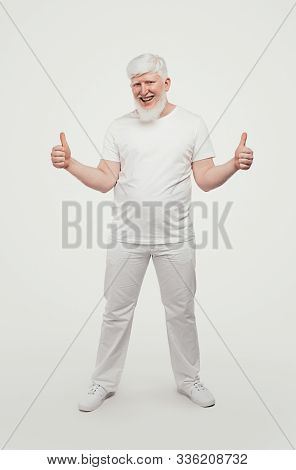 Cheerful Smiling Male With Albinism In White Clothes Approving Expression With Showing Success With 