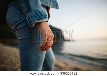 Married Woman In Denim Clothes Standing In The Sea Coast. Closeup Female Hand With Golden Ring. Reat