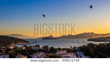 Bright Colorful Sunset In The Beautiful Bay Of The Aegean Sea With Islands, Mountains, Boats And Bir