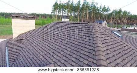 House With A Roof From A Bituminous Tile. Bituminous Tile For A Roof. A Roof From A Bituminous Tile.