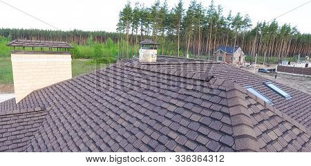 House With A Roof From A Bituminous Tile. Bituminous Tile For A Roof. A Roof From A Bituminous Tile.