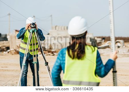 Selective Focus Of Surveyors With Digital Level And Survey Ruler On Construction Site