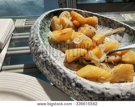 Restaurant On The Pier. Fried Potatoes With Onions On A Platter.