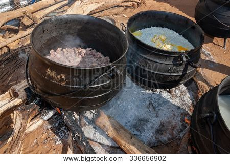 Outdoors African cooking in the kitchen with three legged pots for celebrations and weddings