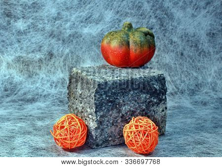 Lightly Decorated Concrete Stone With Pumpkin And Bast Balls
