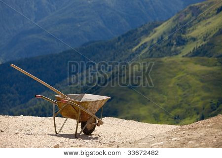 Empty wheelbarrow in mountain landscape