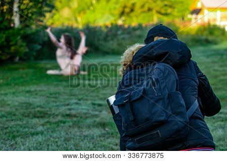 Behind View Photo Of A Person Watching Another Person Practicing Yoga Positions On A Grass Field In 
