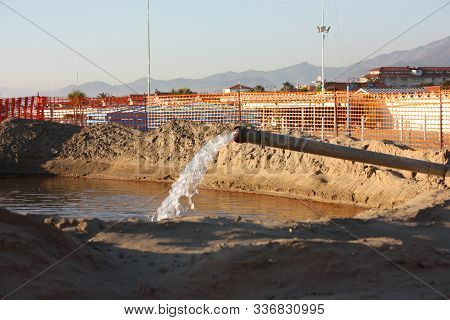 Work In Progress On The Sandy Beach. Open Yard, Between Pipes And Orange Bars Before The Seasonal Su