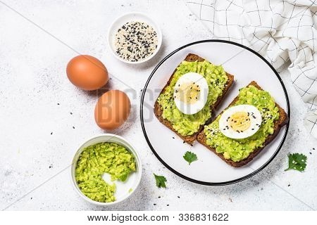 Avocado Sandwiches With Boiled Egg And Cereal Bread On White Background, Top View.