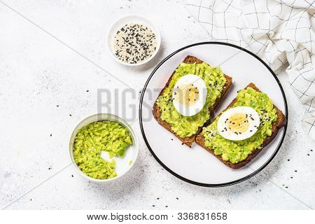 Avocado Sandwiches With Boiled Egg And Cereal Bread On White Background, Top View.