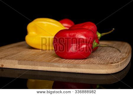 Group Of Four Whole Hot Chili															 Habanero On Bamboo Cutting Board Isolated On Black Glas