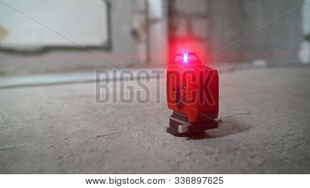 Laser Level At Work. Laser Level And Concrete Walls And Floor. Apartment Renovation.