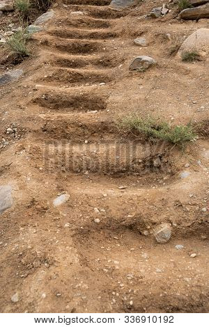 Stairs On Sandy Hillside. Steps Carved Into Rock, Ancient Human Settlement
