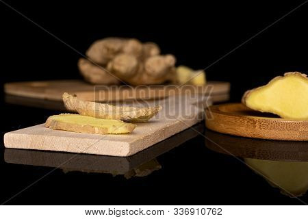 Group Of Two Whole Three Slices Of Fresh Brown Ginger On Bamboo Cutting Board On Round Bamboo Coaste