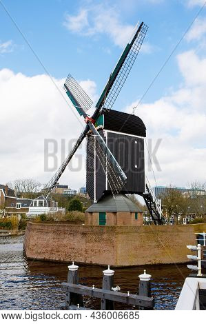 Cityscape Of Leiden, The Netherlands. View Of New Rhine River And Dutch Houses And Traditional Windm