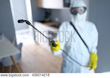 Person In Protective Suit And Mask Disinfects Kitchen