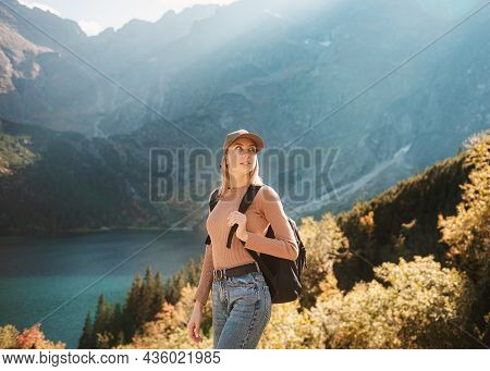 Wanderlust And Travel Concept. Stylish Traveler Girl In Hat Looking At Map, Exploring Woods. Young O