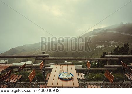 Misty Mountians Over Cafe Terrace With Breakfast Table. Natural Landscape And Local Outdoor Restaura