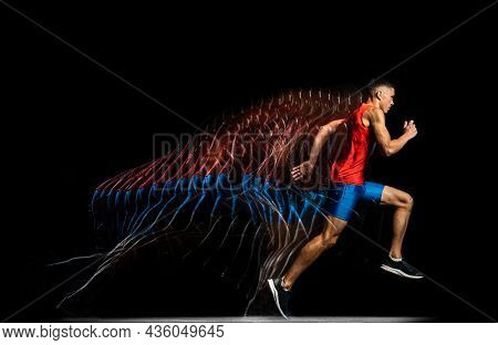 Full-length Portrait Of Young Male Athlete, Professional Runner In Motion Isolated Over Black Backgr