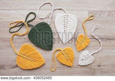 Macrame Leaves In Yellow, Green  And Natural Color On The Wooden Background. Cotton Rope Decor Macra
