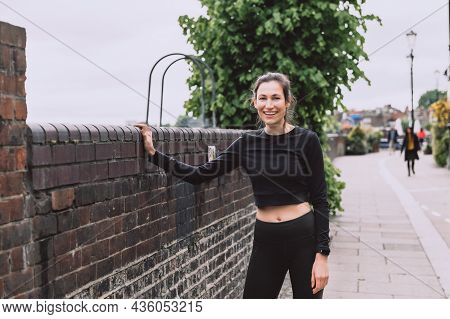 Beautiful Young Slim Woman Is Smiling And Stretching After Running. Stay Healthy, Do Sport Outside. 