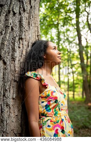 Beautiful Portrait Of A Happy Mixed Race African American Woman Wearing A Yellow Floral Dress Leanin