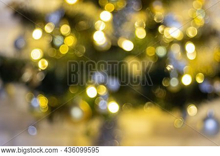 Defocused Christmas Tree Garland Illumination. Blurred Sparkling Fairy Background. Silver And Gold L