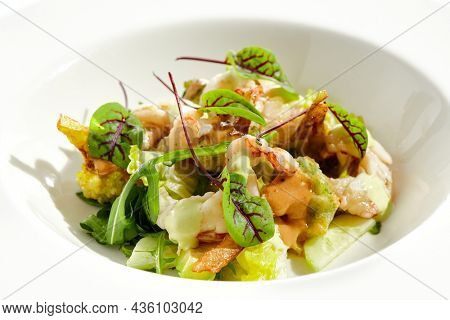 Green salad with broccoli, avocado, shrimps on white plate. Healthy dinner - Salad broccoli and prawns. Clean eating. Green bowl with vegetables and shrimps. Tempura broccoli with avocado, leaf, prawn