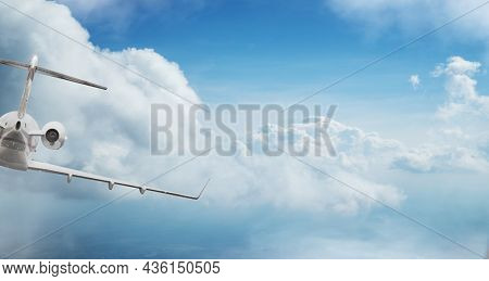 Private jetplane flying above dramatic clouds